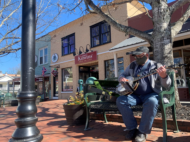 A man outside of Kilwins playing the banjo on the Dahlonega Square. Photo by Luke Rowe