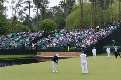 Tiger Woods (center), Rory Mcllroy, and Freddie Couples (far right) practice putting on hole 15. Photo by Hamilton Keener 