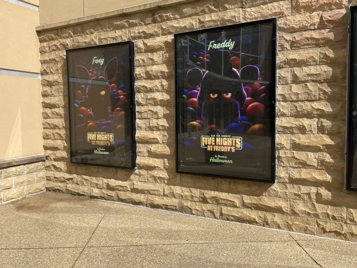 Two posters advertise the FNAF movie outside the AMC in Cumming GA. The posters feature two of the movies main characters Foxy the Pirate Fox and the bear, the myth, the legend, Freddy Fazbear.