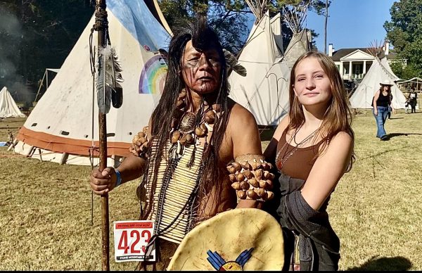 Native American warrior poses for picture with Alanna Ellis in authentic tipi camp 