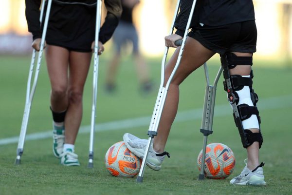 Two teens on crutches with ACL problems as a result of playing soccer (Motus Physical Therapy)