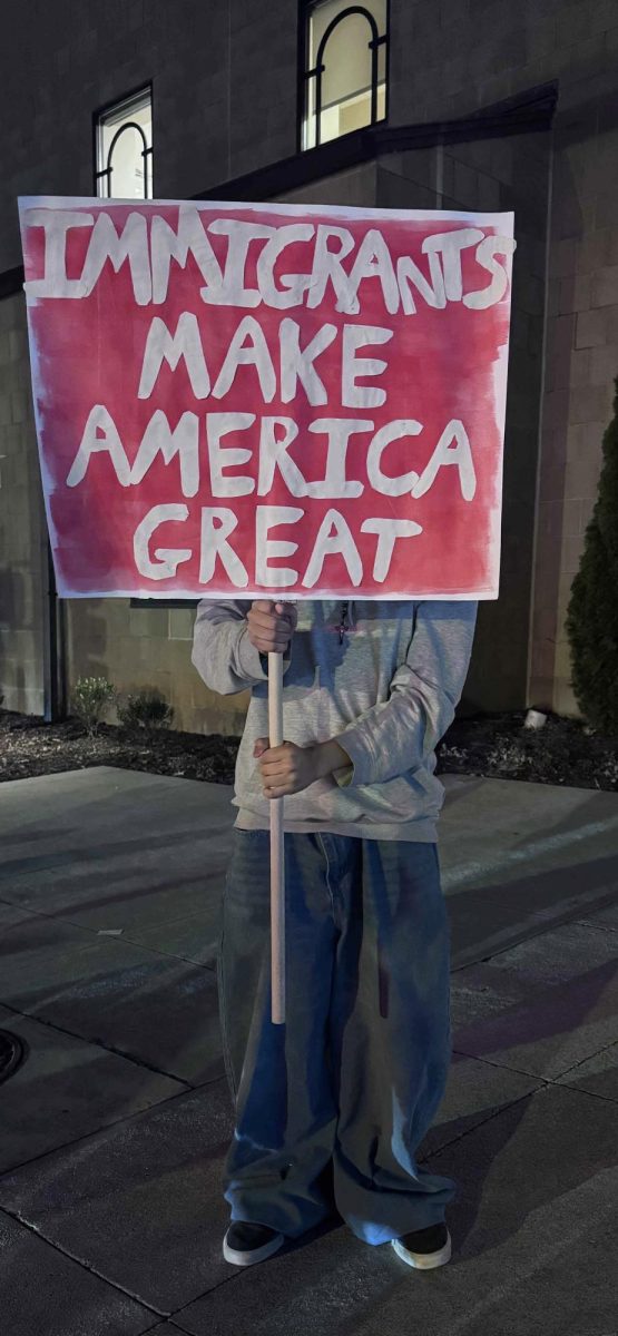 Protester carrying "Immigrants Make America Great" sign during the Jan. 29 mass deportation protest.