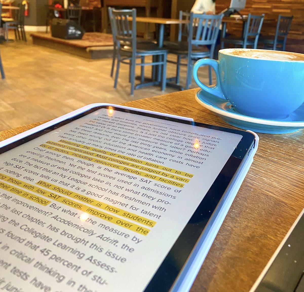 A student academically reading at TradeWind Coffee Shop.
